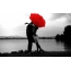 Couple kissing under a red umbrella