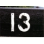 "13" balti dažai ant juodo lentos
