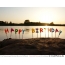 Gražus saulėlydis, paplūdimys, žvakės Happy Birthday