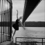 芭蕾舞女演员穿着黑色连衣裙在桥下