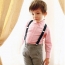 Băiat într-o cămașă roz și pantaloni cu jartiere
