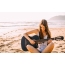 Garota na praia com uma guitarra