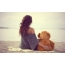 ילדה עם דוב על החוף
