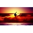 Surfer på våg, vacker solnedgång