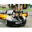 Two girls in boots on the hood of a black car
